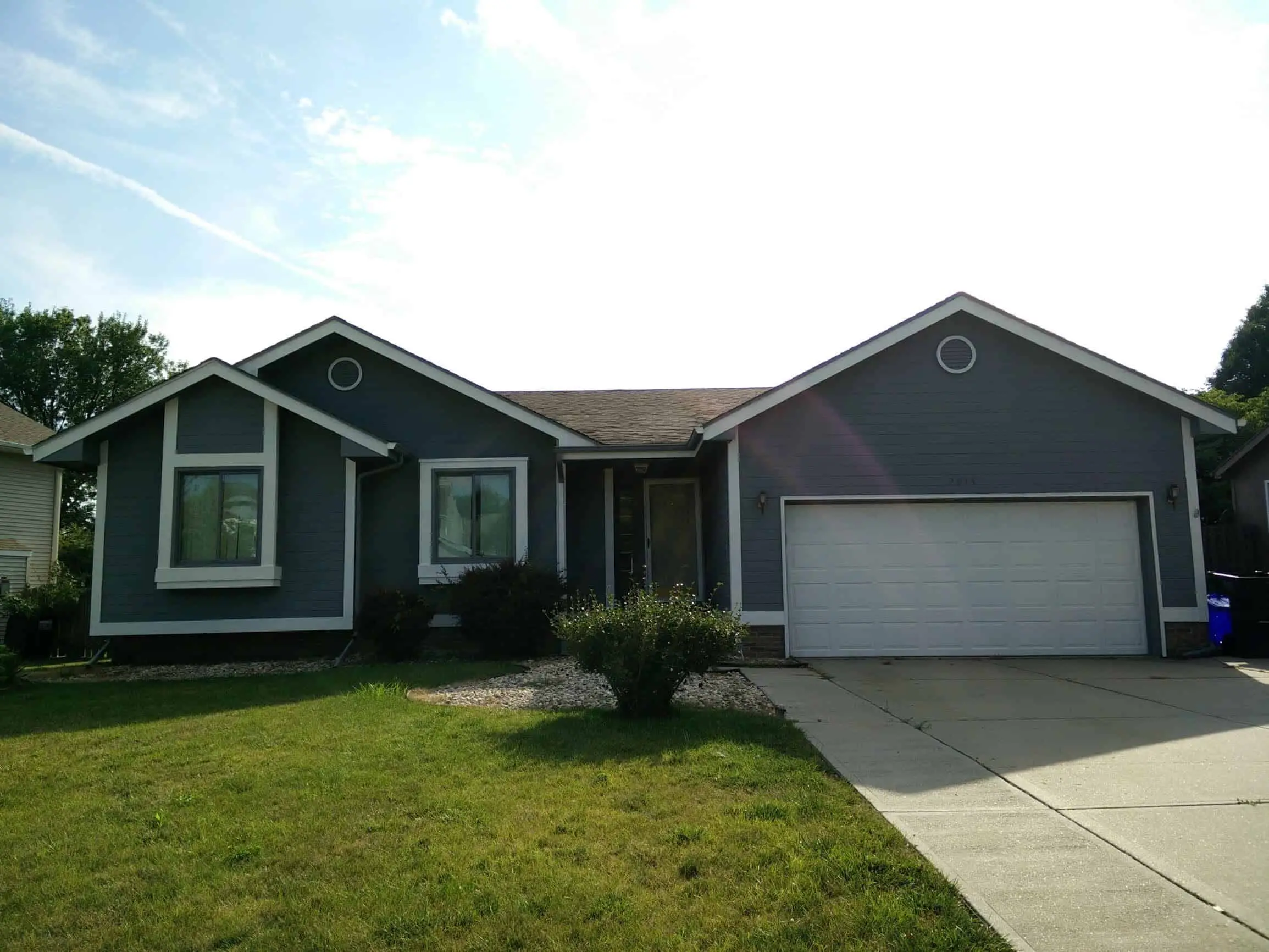 Cityscape gray house with white trim painted by Omaha house painters