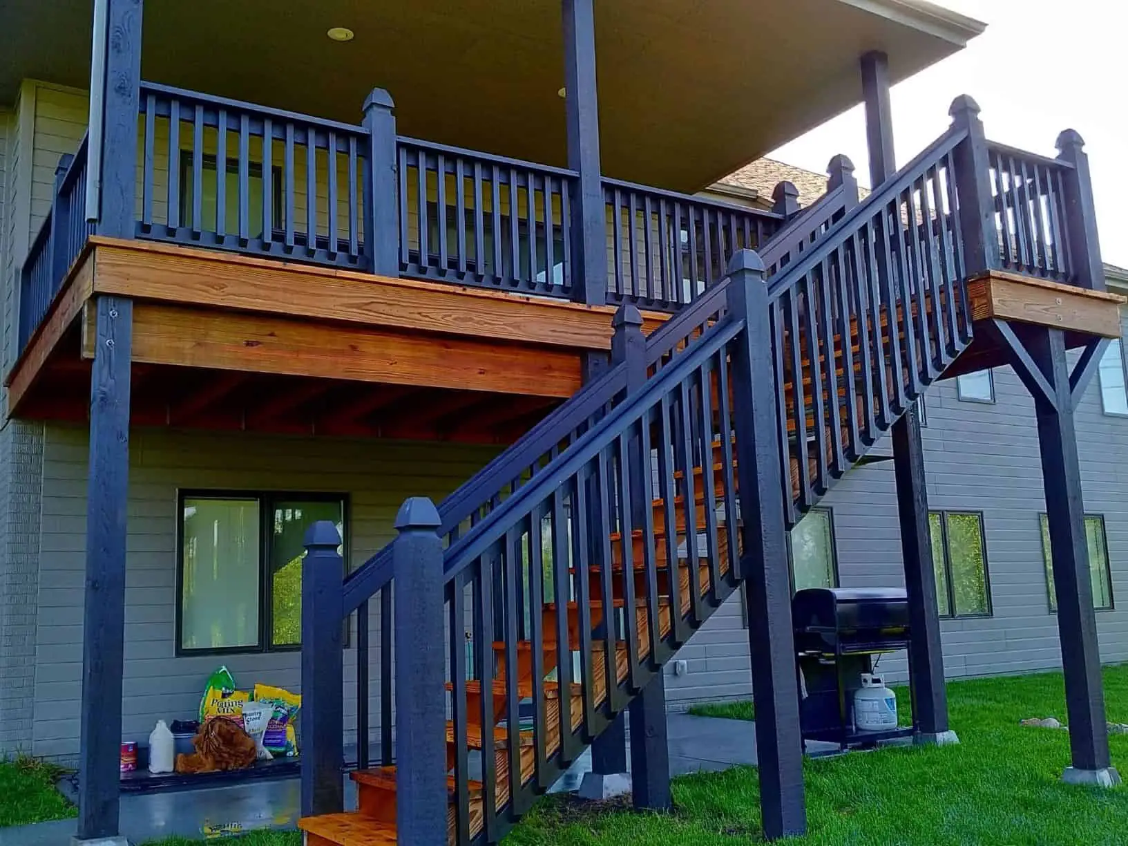 Two-tone deck with dark blue railings and a semi-transparent, golden body painted by Omaha house painters